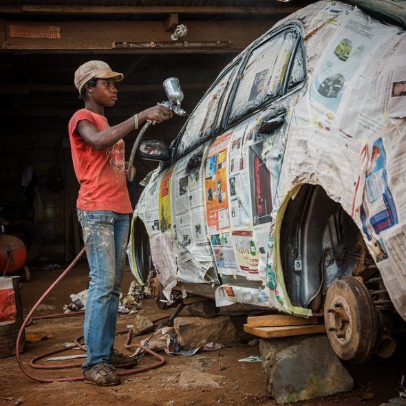 Una joven pinta un coche con spray en Tarkwa, Ghana. Foto: Nana Kofi Acquah / EverydayAfrica.