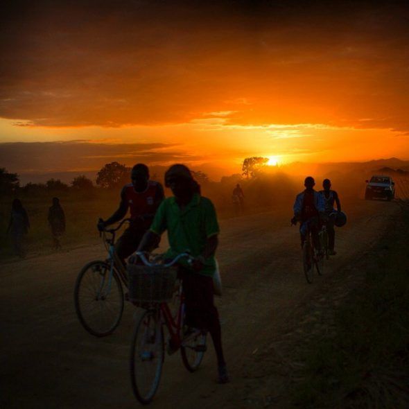 Ciclistas recorren una carretera mientras atardece en la zona rural de Ifkara, Tanzania. Foto: Nana Kofi Acquah / EverydayAfrica.