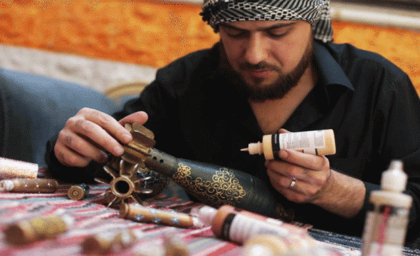 Akram Abu al-Fawz pega las piezas de uno de sus adornos construidos mediante piezas de misiles y metralla que el mismo recoge en su ciudad, Duma. Foto: Siriauntold