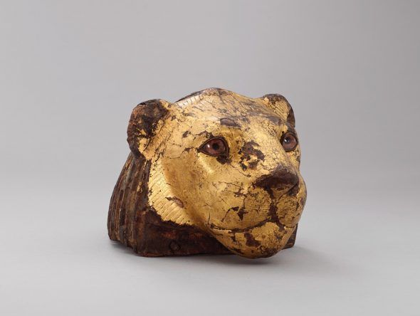 Elemento de un mueble en forma de cabeza de león.