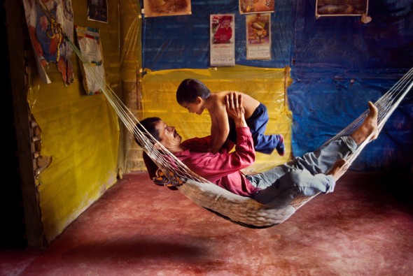 Un padre y su hijo juegan en una hamaca en su casa. La Esperanza. Colombia. 2004.