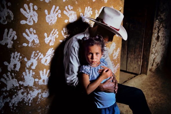 Un hombre y su nieta frente a una pared decorada con huellas de manos. La Fortuna. Honduras, 2004. Foto: Steve McCurry.