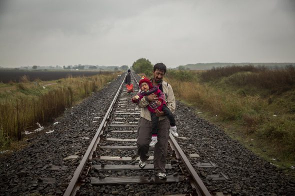 Un padre y su hijo caminan por las vías del tren en Hungría, a pocos metros de la frontera con Serbia.