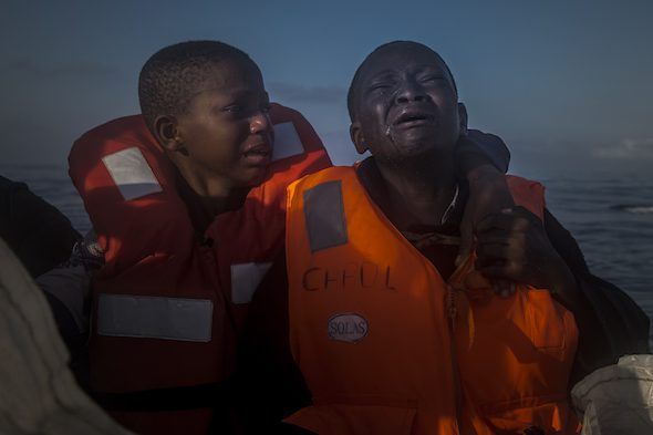 Una niña de 11 años de nigeria, a la izquierda, que aseguró que su madre había muerto en Libia, llora junto a su hermano de 10 años al ser recatados de una patera repleta de inmigrantes. Foto: Santi Palacios/Associated Press.