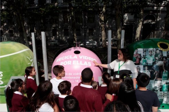 Niños y niñas recorriendo la exposición 20 añazos de reciclaje de vidrio en Madrid. 