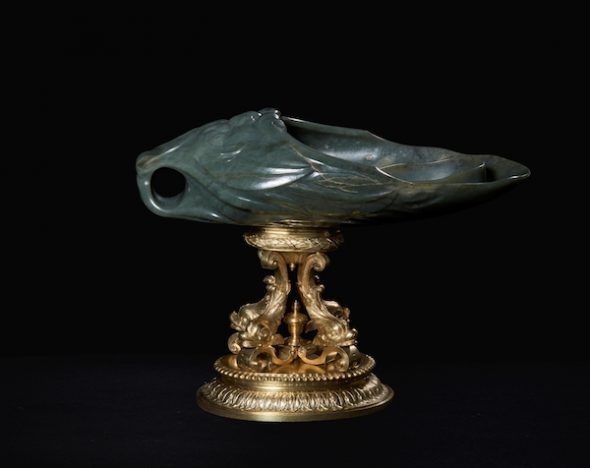 Vaso de jade en forma de mascarón sobre cuatro delfines. 