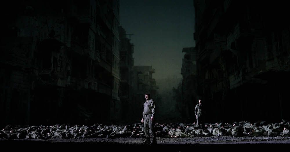 'Idomeneo' en el Teatro Real, con la proyección al fondo de la foto de la localidad siria de Deir Ezzor devastada por la guerra. Foto: Javier del Real.