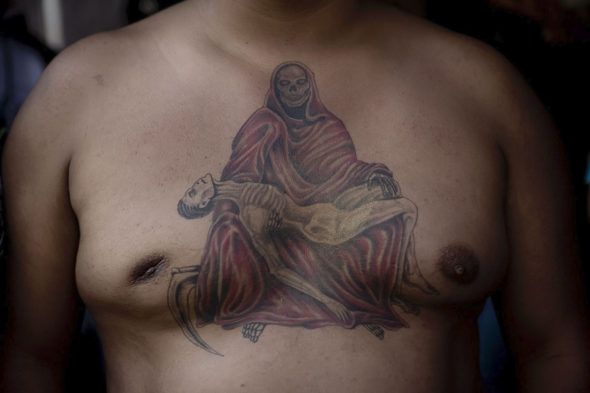 Tepito, México. Un hombre muestra su tatuaje del pecho en honor a la Santa Muerte. Los tatuajes son comunes y son vistos como una ofrenda más. Foto: Adriana Zehbrauskas