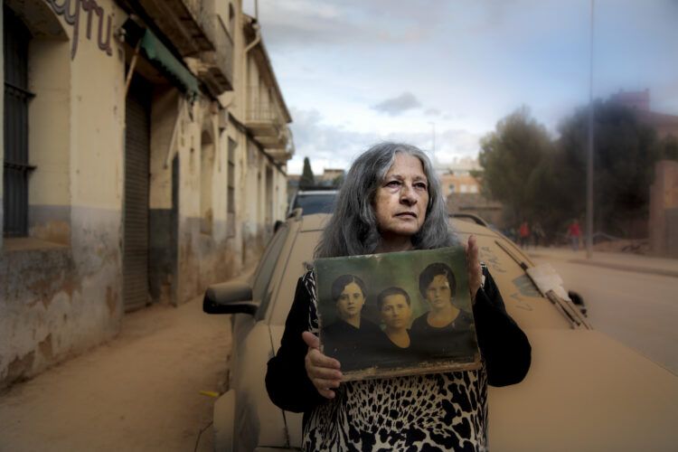 Ana Carmen Llobel Chambó, de Algemesí sostiene en sus manos la foto de su madre, su tía y su abuela. Foto: Victoria Iglesias.